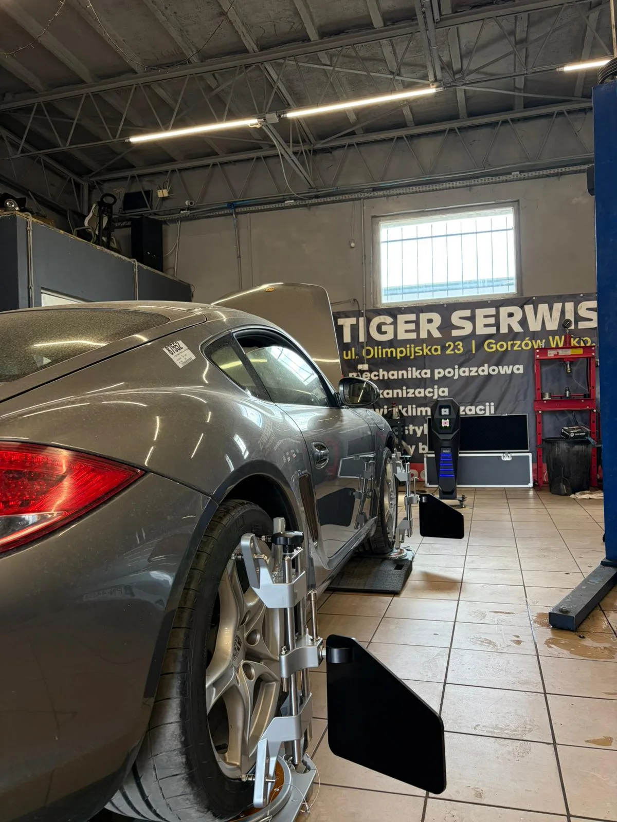 Porsche Cayman na stanowisku geometrii kół 3D – baner Tiger Serwis Olimpijska 23 Gorzów Wielkopolski w tle