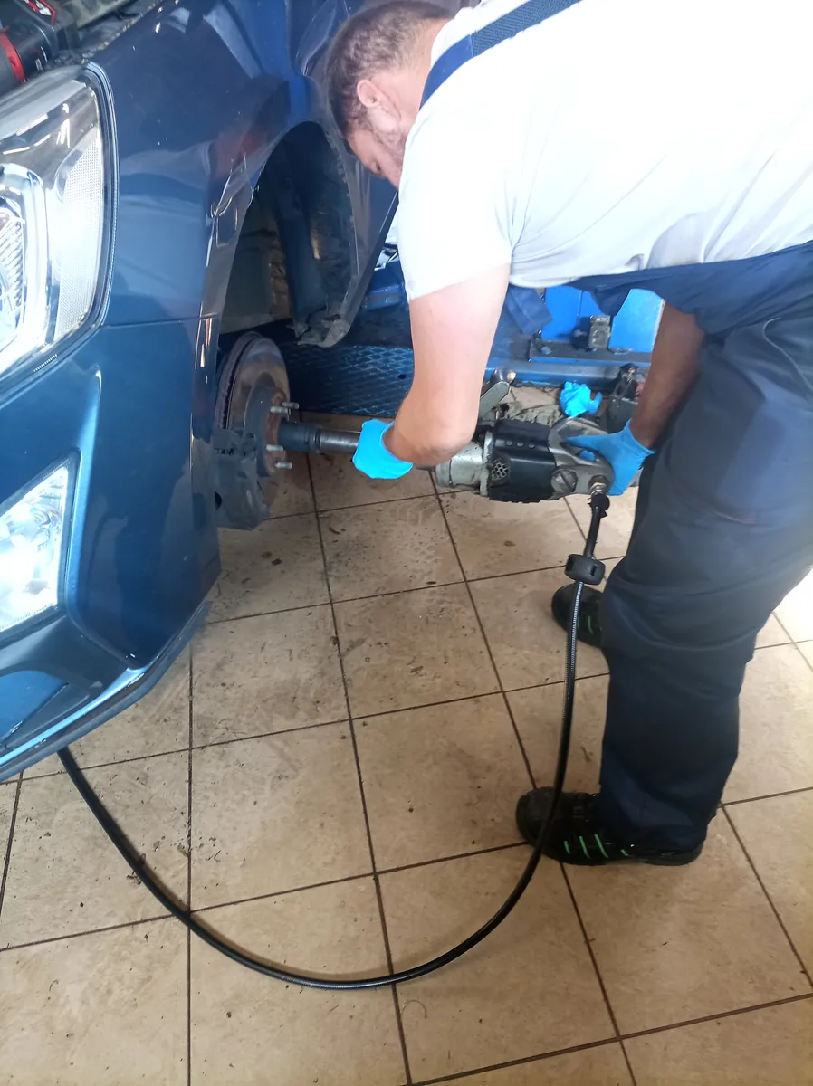 Mechanik przy piaście z kluczem pneumatycznym – serwis zawieszenia Tiger Serwis